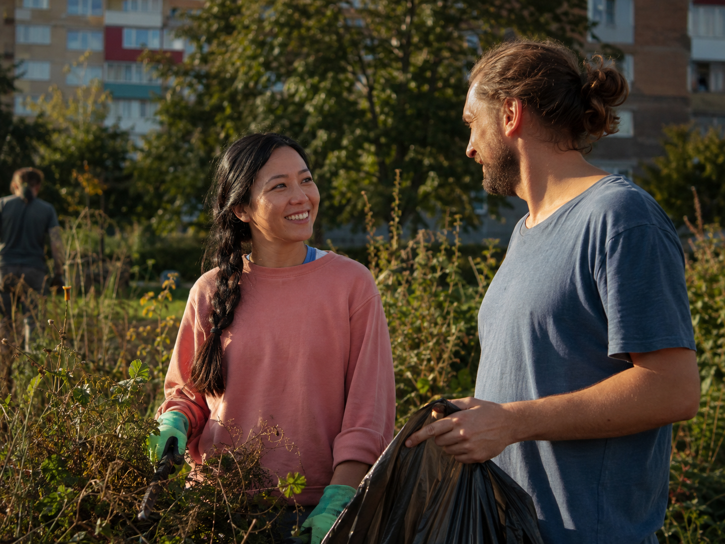Adults talking while tidying a shared public garden area