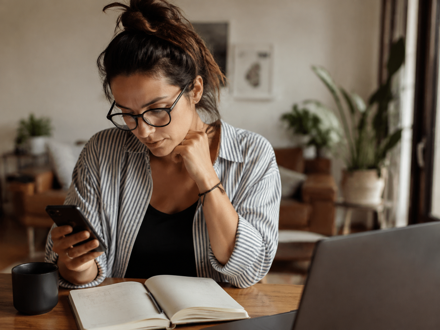 Adult composing a message beside a notebook of product ideas