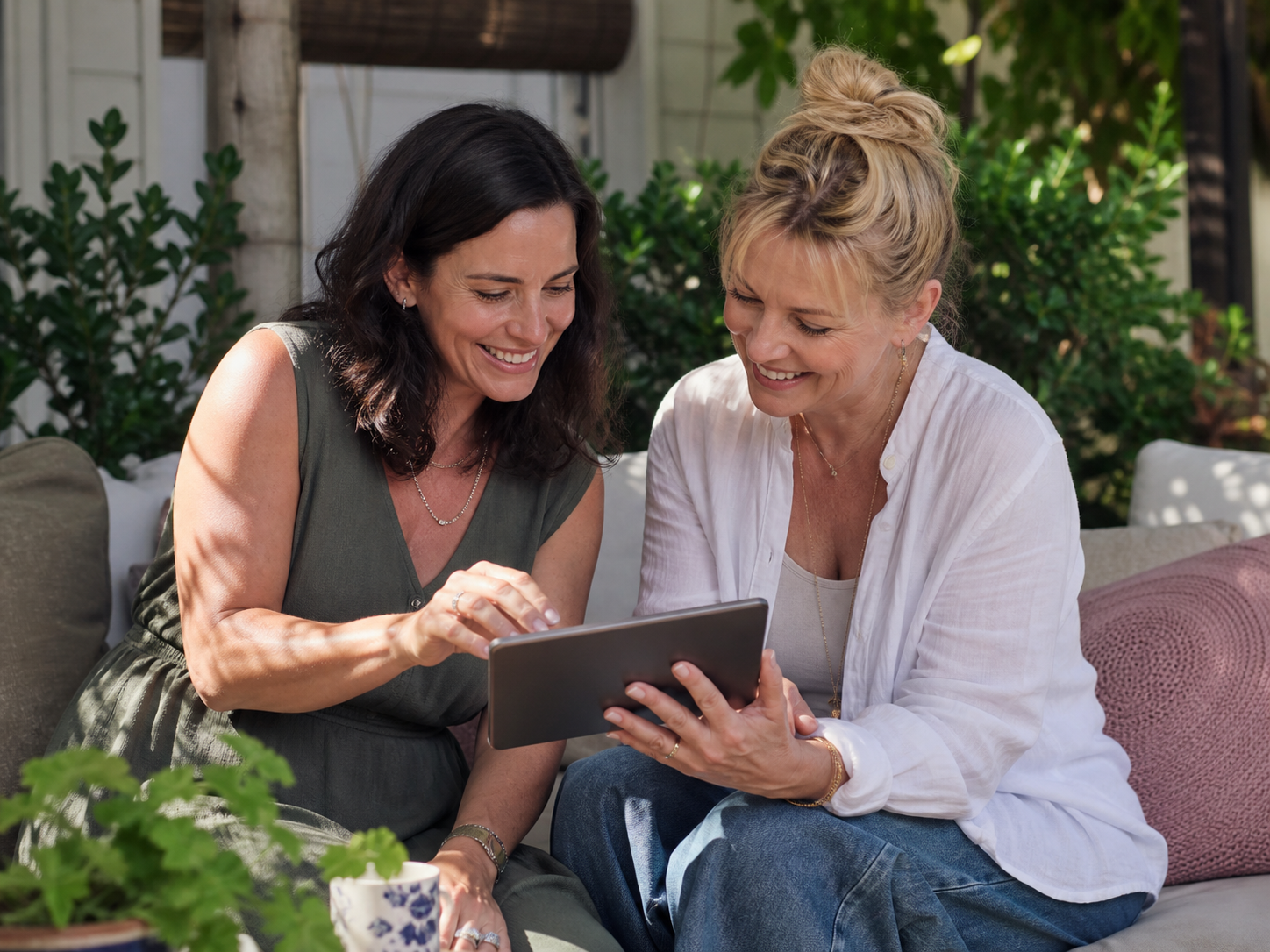 Two adults looking at a tablet together in a garden