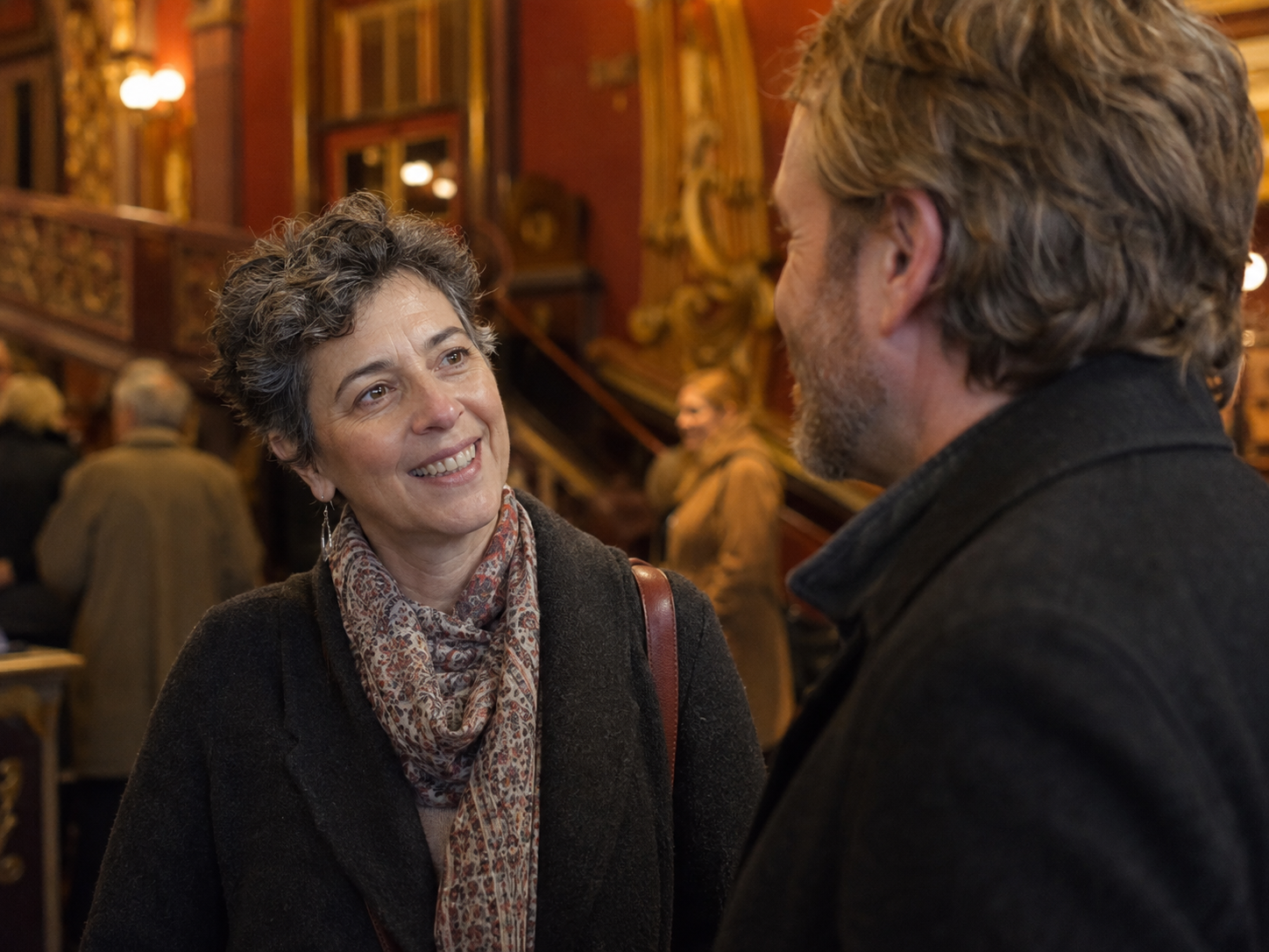 Adults meeting in a public theater foyer