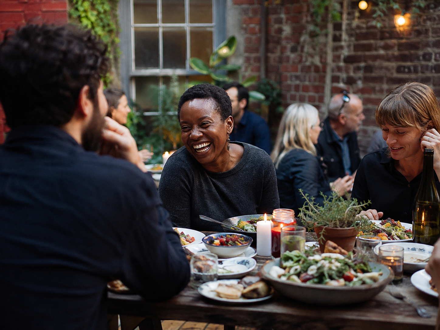 Adults sharing a meal in a busy neighborhood courtyard