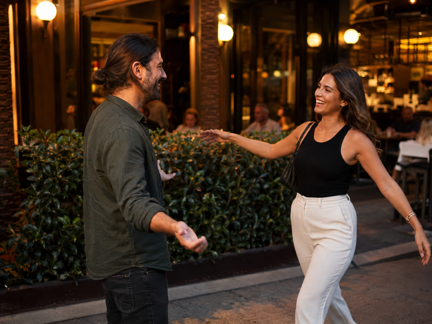 Adults greeting outside a lively illuminated restaurant