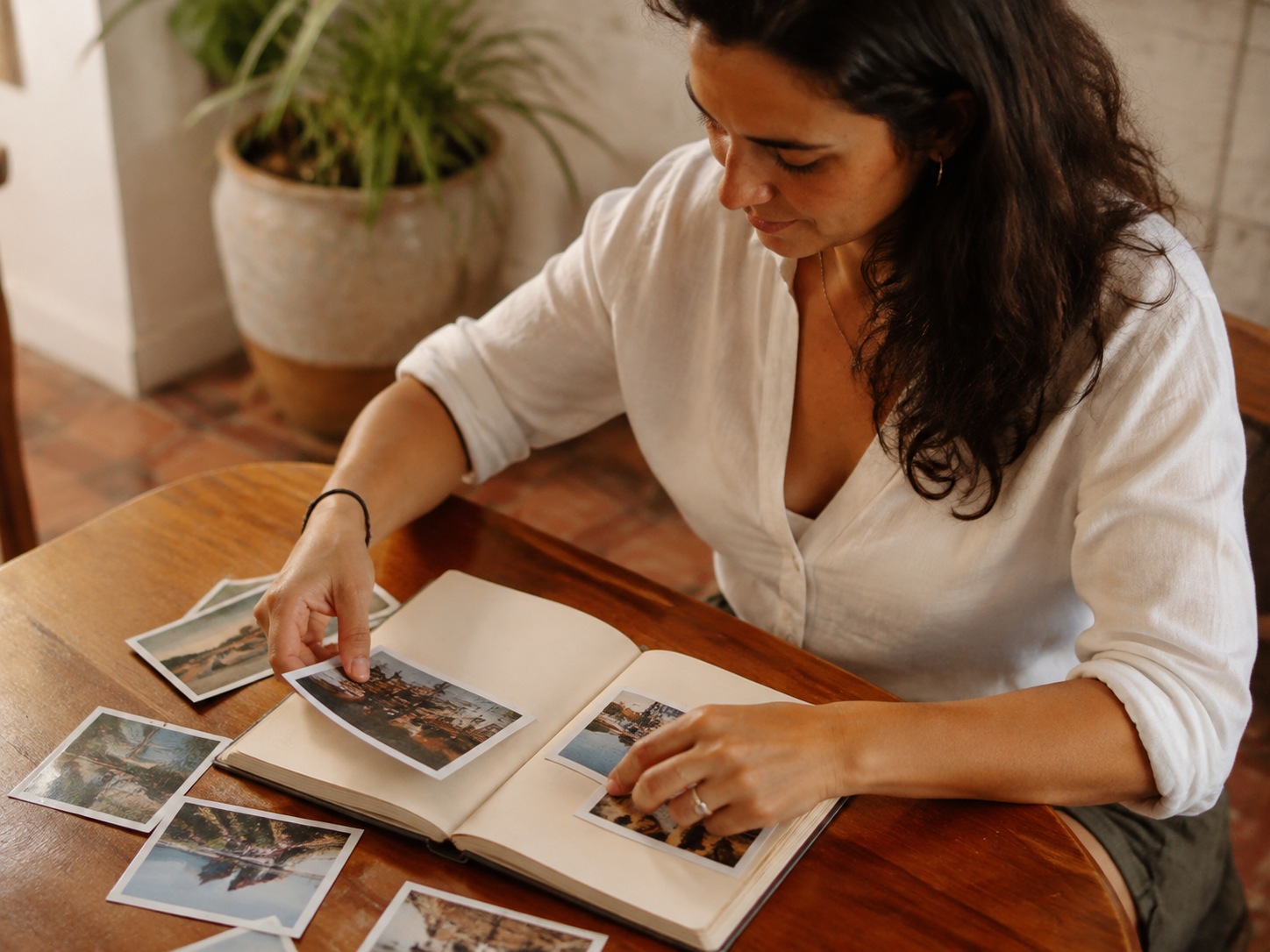 Adult arranging travel photographs in a journal